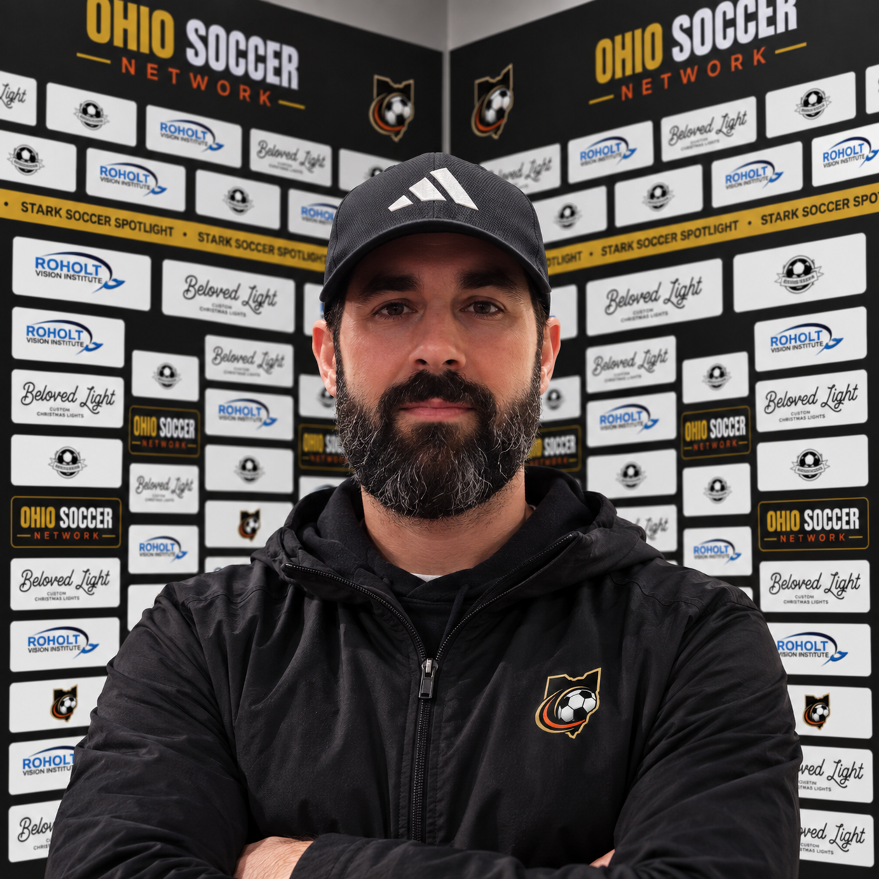 Nic Fernandez, founder of Ohio Soccer Collective, in front of a sponsor media wall